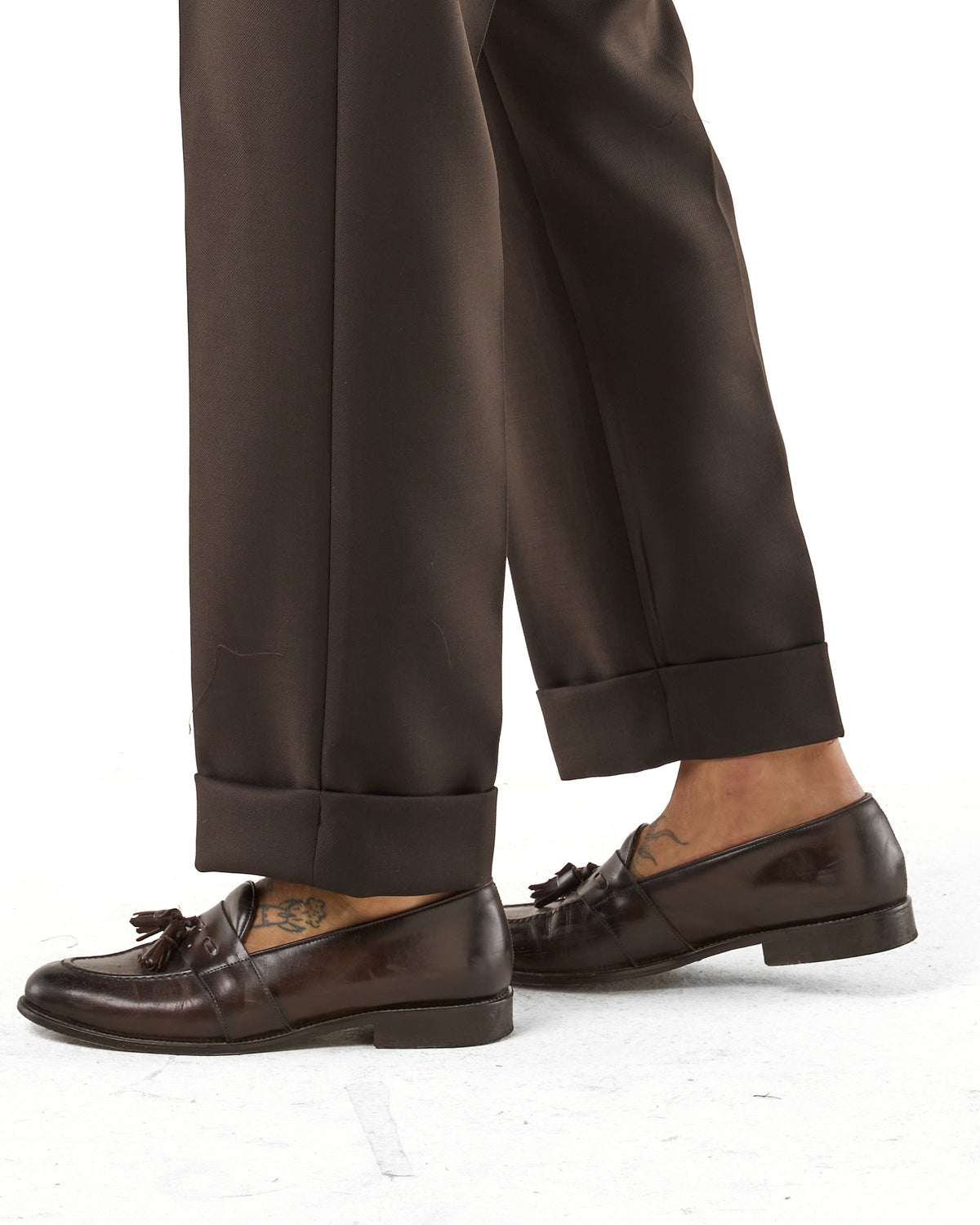 Pantalones de pernera ancha en marrón oscuro con hebillas laterales en diagonal.